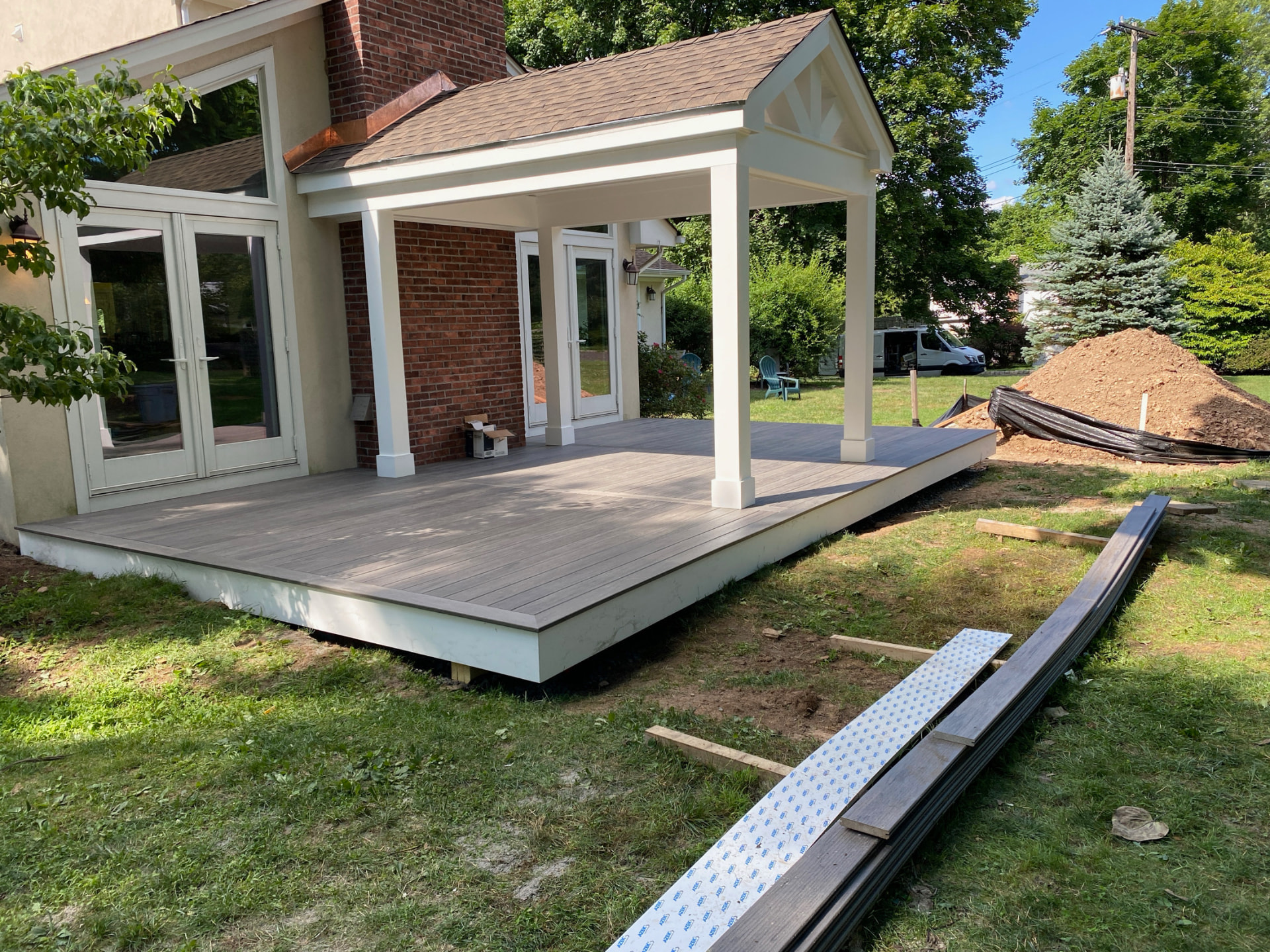 New covered porch with deck built onto a brick home